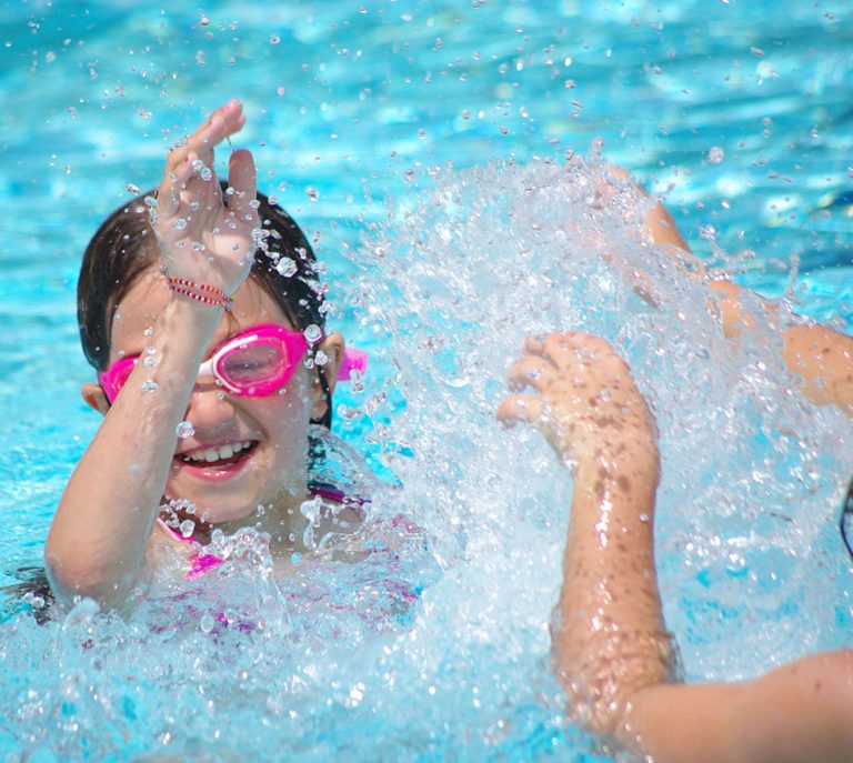 Petite fille jouant dans la piscine du camping dans le morbihan avec piscine couverte et Chauffée le Ty Nenez